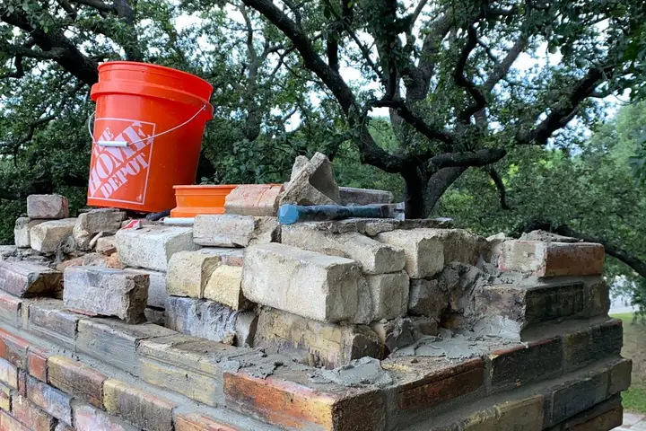 Brick chimney being rebuilt course by course