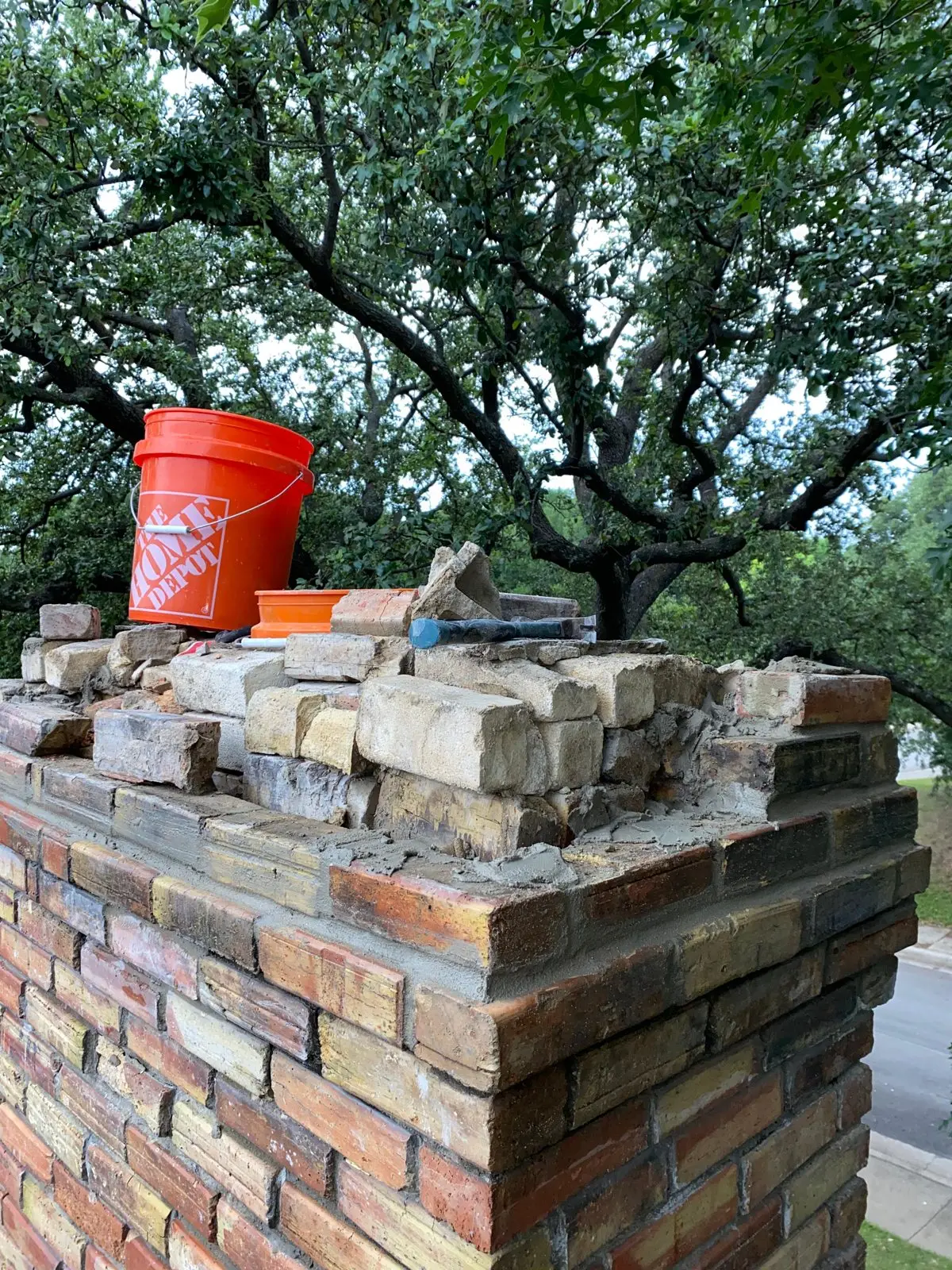 Brick chimney being rebuilt course by course