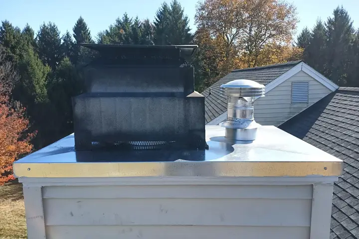 New metal chase cover and cap on a factory-built chimney