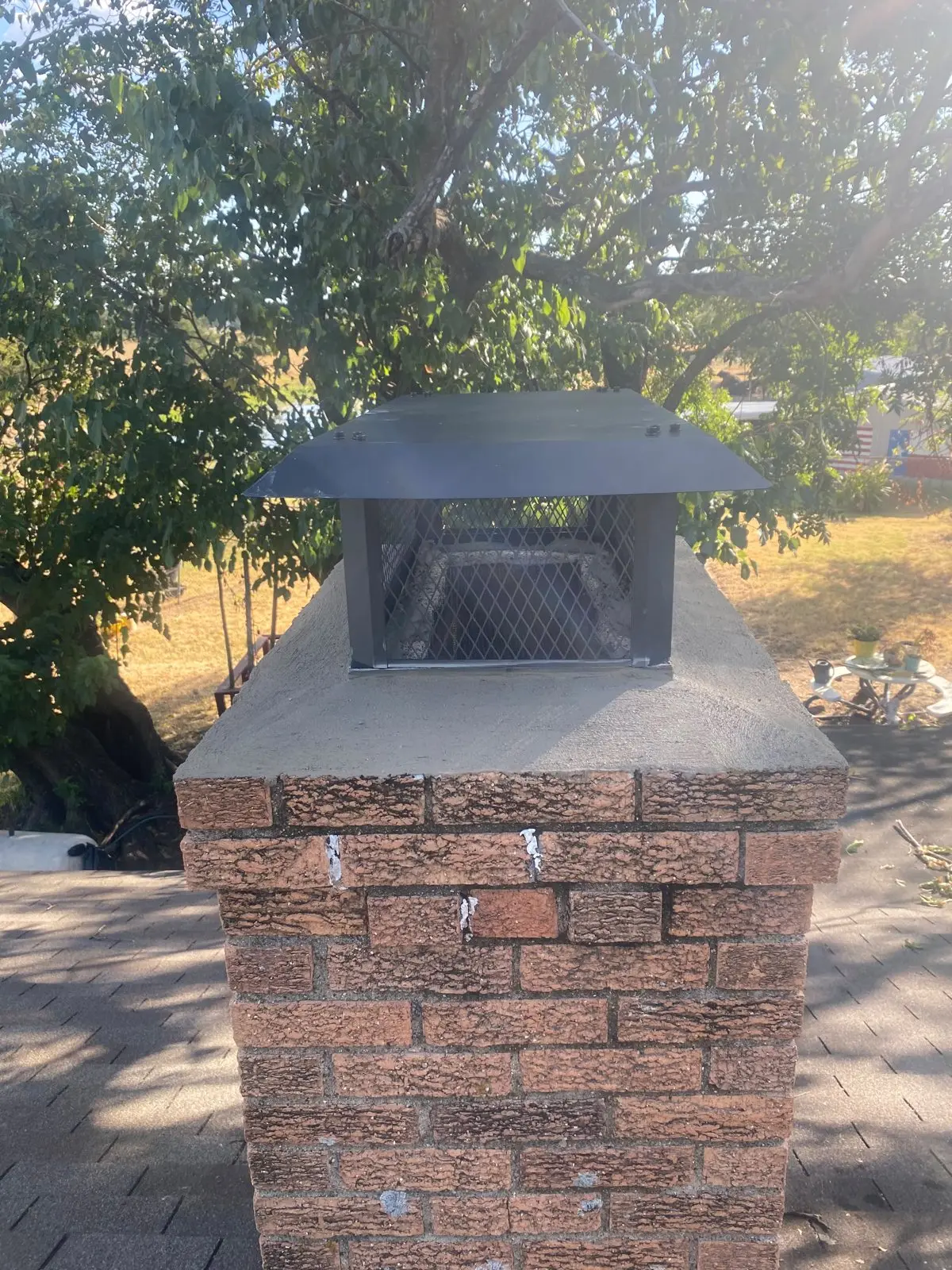 New chimney cap installed on a brick chimney