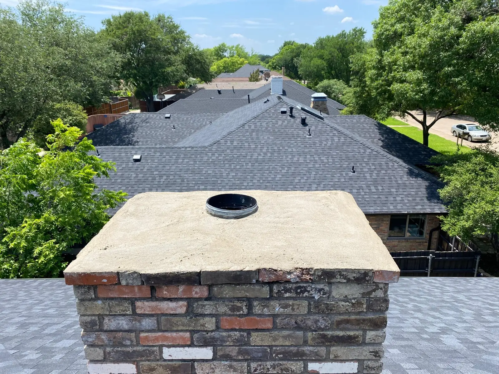 Freshly rebuilt concrete chimney crown on a brick chimney