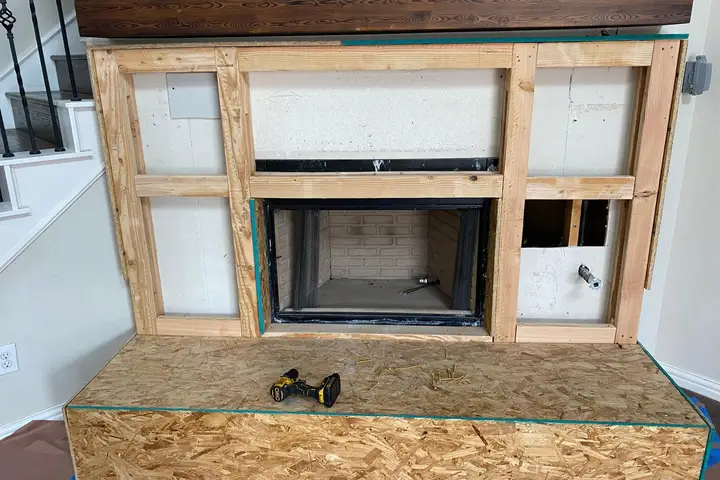 New fireplace insert being installed in framed wall