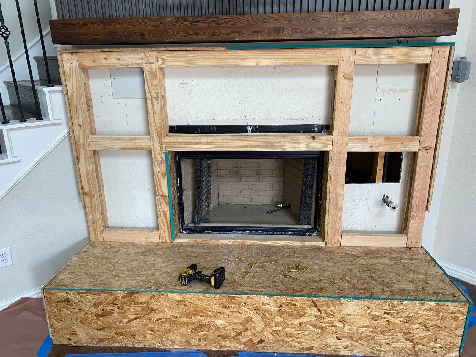 New fireplace insert being installed in framed wall