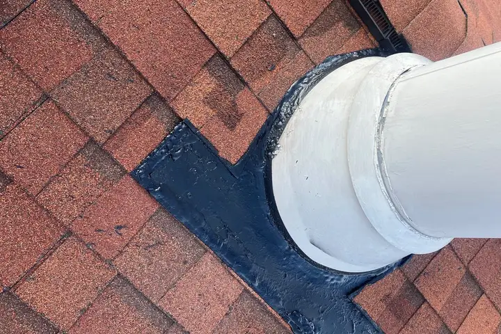 Sealed flashing around a chimney pipe on a shingle roof