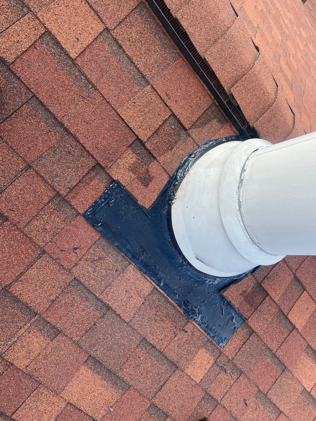 Sealed flashing around a chimney pipe on a shingle roof