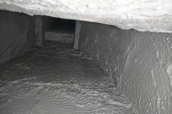Heavy creosote buildup inside a chimney flue before removal