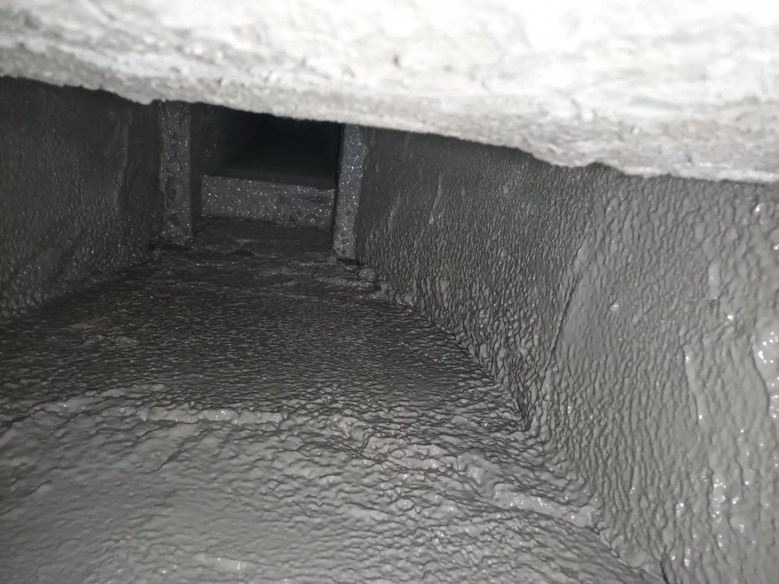 Heavy creosote buildup inside a chimney flue before removal