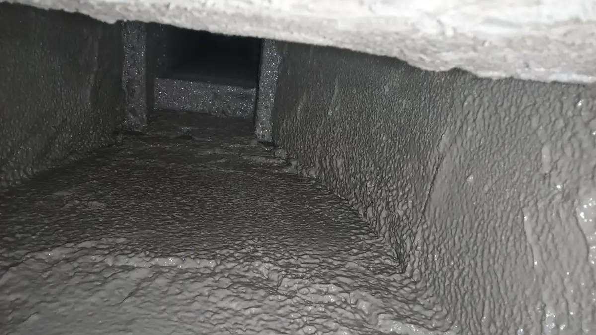 Heavy creosote buildup coating the inside of a chimney flue, seen from the smoke chamber