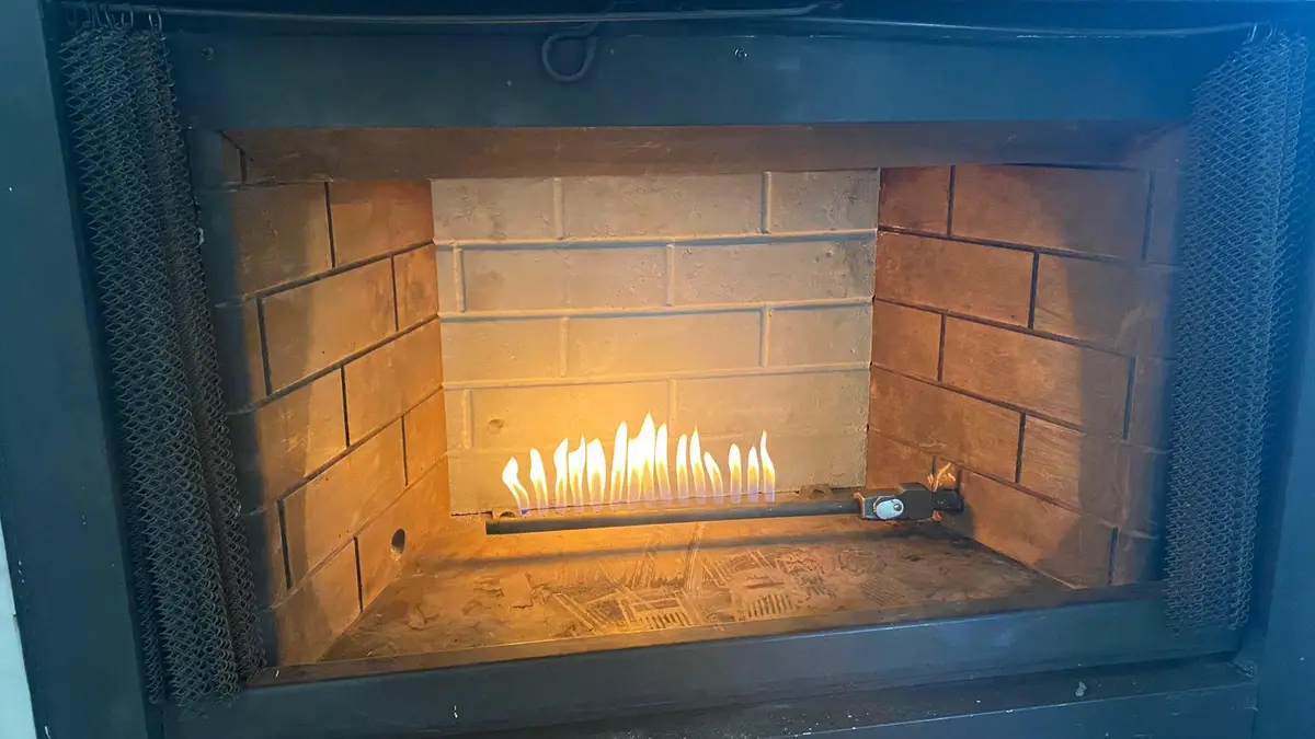 Gas fireplace burner lit and running after a service visit in an Arlington-area home