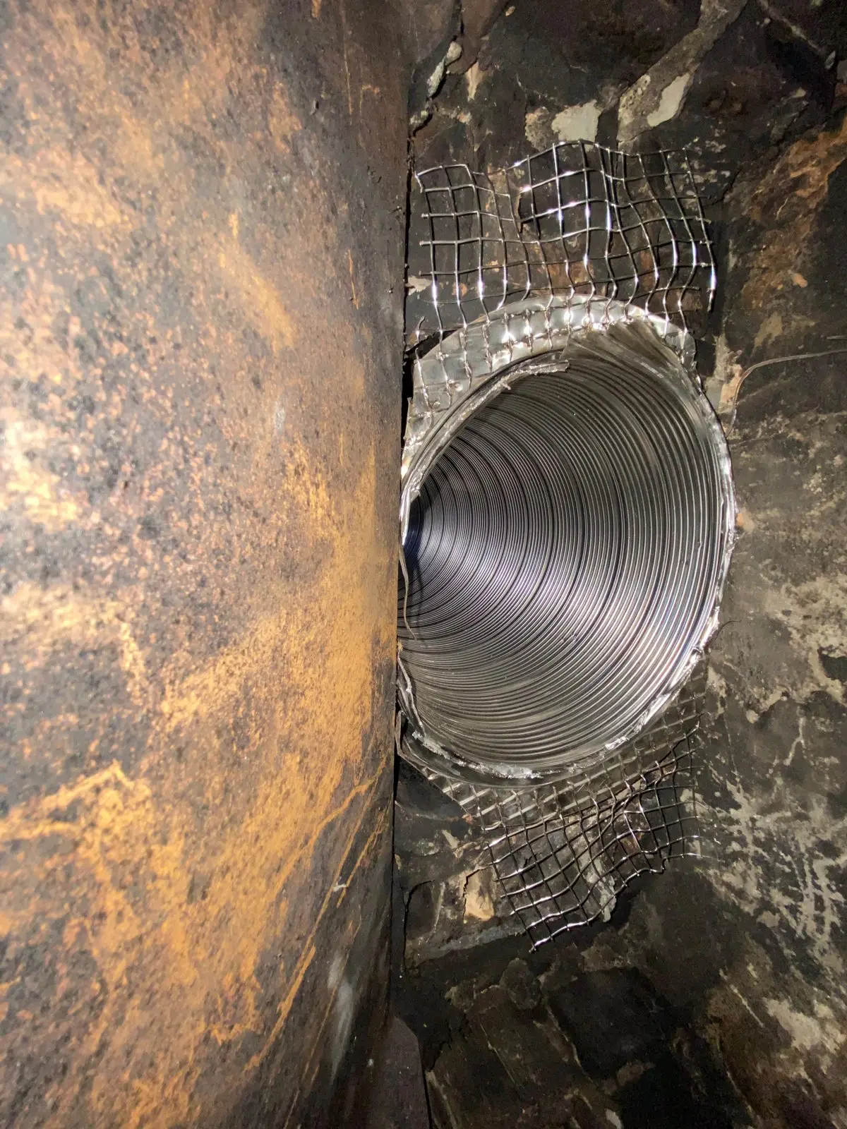 Stainless steel chimney liner installed inside a masonry flue