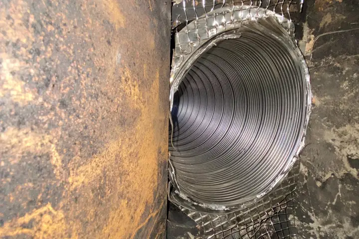 Stainless steel chimney liner installed inside a masonry flue