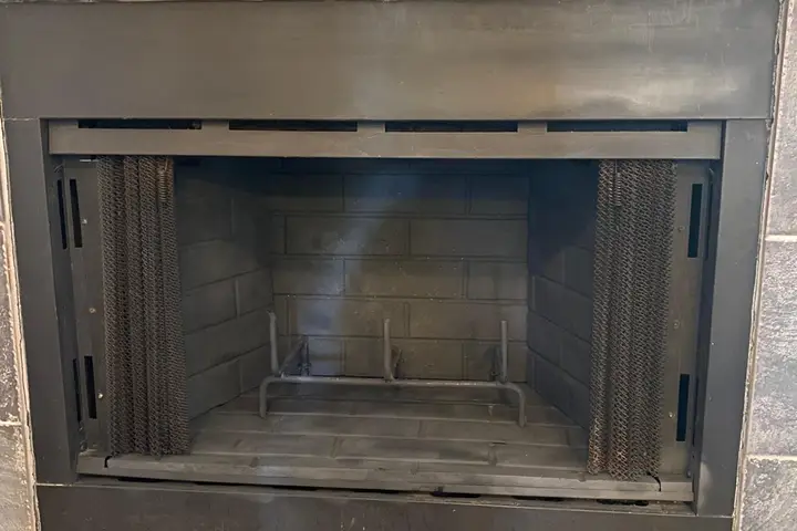Clean prefab fireplace firebox during an inspection