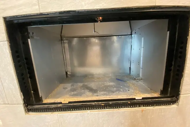 Prefab fireplace firebox with soot before cleaning