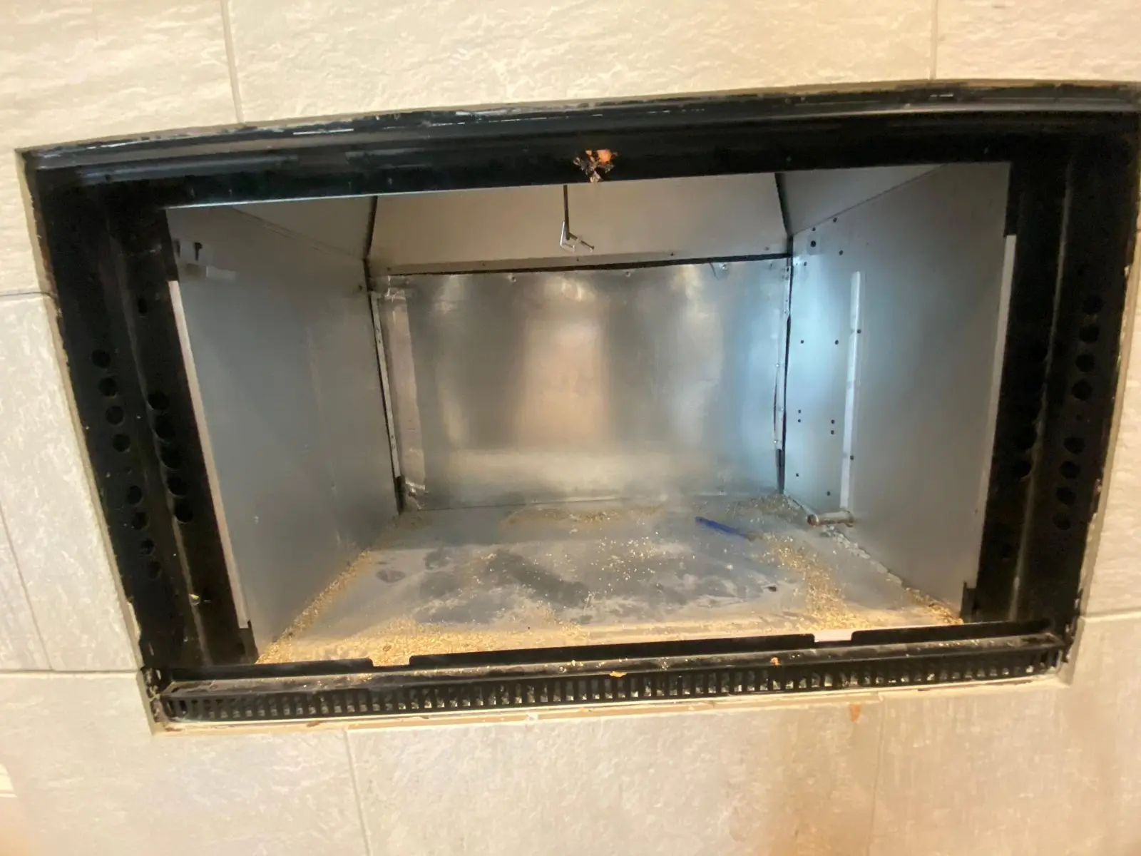 Prefab fireplace firebox with soot before cleaning