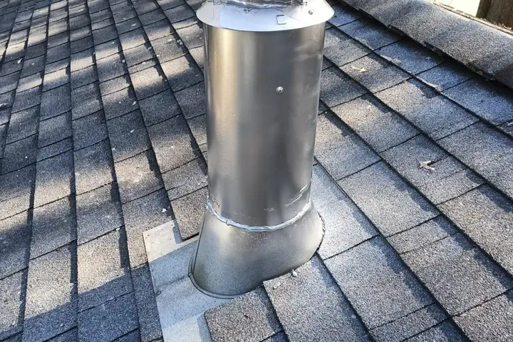Wood stove vent pipe and cap on a roof