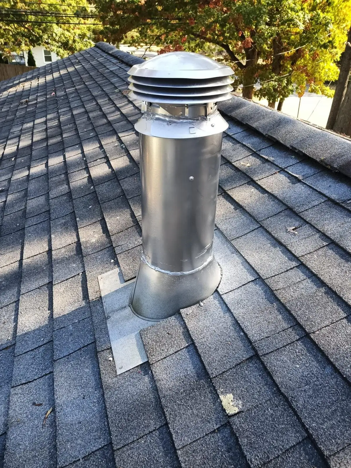 Wood stove vent pipe and cap on a roof